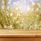 Empty wooden deck table over blurred bokeh summer flowers background for product montage