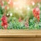 Empty wooden deck table over blurred flower field background for product montage display. Spring or summer