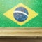 Empty wooden deck table over Brazil flag bokeh background.