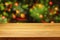 Empty wooden deck table over Christmas tree bokeh background