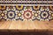 Empty wooden deck table over mosaic ornament wall background