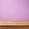 Empty wooden deck table over purple violet wallpaper. Easter spring background