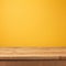 Empty wooden deck table over yellow wallpaper