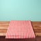 Empty wooden deck table and red checked tablecloth