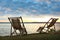 Empty wooden deckchairs on hill near  river