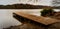 Empty wooden dock leading into a smooth lake