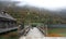 An empty wooden pier by beautiful lakeside on a misty foggy morning