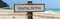 Empty wooden signboard against tropical sand beach