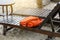 Empty wooden sunbed with orange towels on the beach.