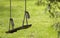 Empty wooden swing on ropes