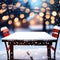 Empty wooden table, blurred Christmas decorated house exterior