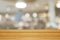 Empty wooden table and blurred modern warm cafe background,