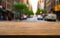 Empty wooden table with blurred street city view background