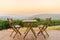 Empty wooden table and chairs on terrace. Beautiful seating with landscape mountains view while sunset.