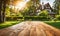 An empty wooden table in the foreground, with a blurred country house in the background against a verdant garden setting