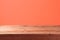 Empty wooden table with over abstract coral color wall background