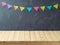 Empty wooden table over blackboard background with colorful banners. Back to school concept for mock up design and product