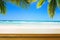 Empty wooden table over blurred tropical beach background. Outdoor party mock up for design and product display