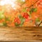 Empty wooden table over fall leaves background. An autumn season concept