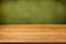 Empty wooden table over grunge green background.