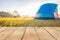 Empty wooden table or plank with dew on green grass and camping blue tent on morning on background.