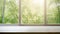 Empty wooden table sits before a window revealing a dense forest. Sunlight casts patterns on the table.