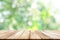 Empty wooden table top with blurred green garden background.