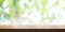 Empty wooden table top with blurred green garden background. Pan