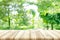 Empty wooden table top with blurred green natural background.