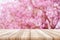 Empty wooden table top with blurred pink cherry or cherry blossom background.