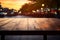 Empty wooden table top in the outdoors cafe with blur background of the sunset city