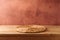 Empty wooden table with wicker place mat over rustic wall  background. Kitchen interior mock up for design and product display