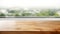Empty wooden table with window and blurred background of city and trees