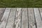 Empty wooden terrace with green lawn