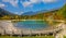 Empty wooden walkway leads around a gorgeous emerald pond in Kranjska Gora.