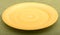 Empty yellow plate on green background