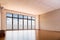 Empty yoga studio with wooden flooring, windows with blue sky