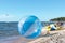 Empty zorb on the inshore waves, water activities, Zorbing extreme attraction for beach vacationers