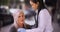 An EMT offers roadside help to a elderly woman