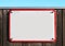 enamel, metal or pottery sign on a rustic wooden wall. red frame, under a bright turquoise sky.