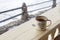 Enamel mug with strong tea and tea bag on a wooden fence on a snowy natural background.