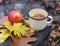 An enameled cup of hot tea, autumn leaves, a rebright autumn portrait of a cute smiling little girl