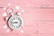 Enamored alarm clock on pink wooden background. Place for text, top view