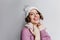 Enchanting curly girl with happy face expression posing in purple sweater and white accessories. Indoor photo of