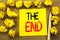 The End. Business concept for End Finish Close written on sticky note paper on the vintage background. Folded yellow papers on the