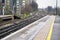 End of platform on train station at London, Mind the step written down, many railway crossings in distance