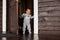 End of quarantine. exit.laughing cheerful baby todler dressed in a warm jumpsuit looking to the camera comes out of the front door