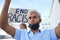 End racism sign, poster and black man protest in face mask, cardboard in urban street for solidarity, race fight and