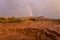 The end of the rainbow arcs over Gooseberry Mesa in Southern Utah USA