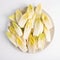 endive on plate top view on white background, salad chicory roots, healthy organic food concept